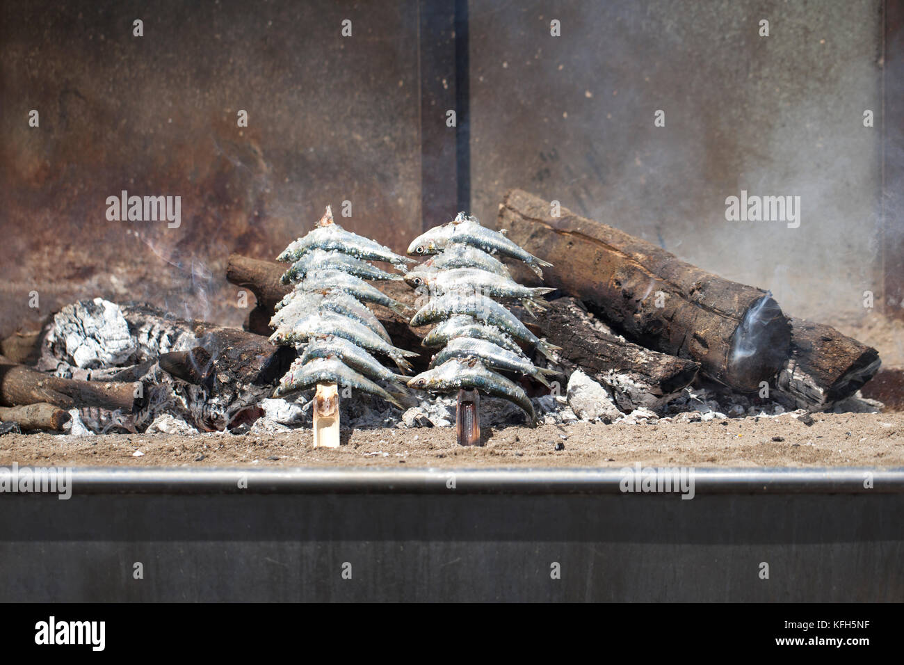 Espeto de Sardines (skewered sardines). This is a tradition in Malaga coast, sardines being slowly grilled over an open wood fire on the beach. Stock Photo