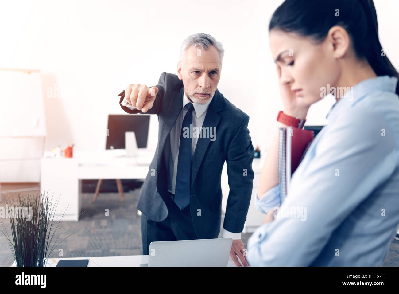 Frustrated male boss fingering at door while firing office worker Stock