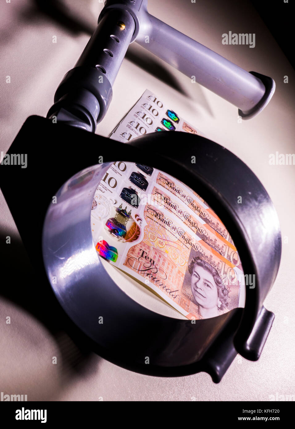 Crutch and new polymer sterling £10 ten pound notes. Concept of link between incapacity and UK pounds, such as disability income and healthcare cost. Stock Photo