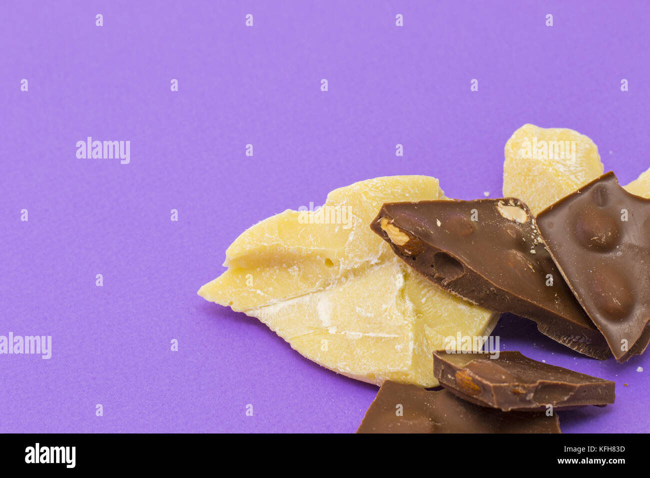 Milk chocolate with almond and cocoa butter on violet background Stock Photo Alamy