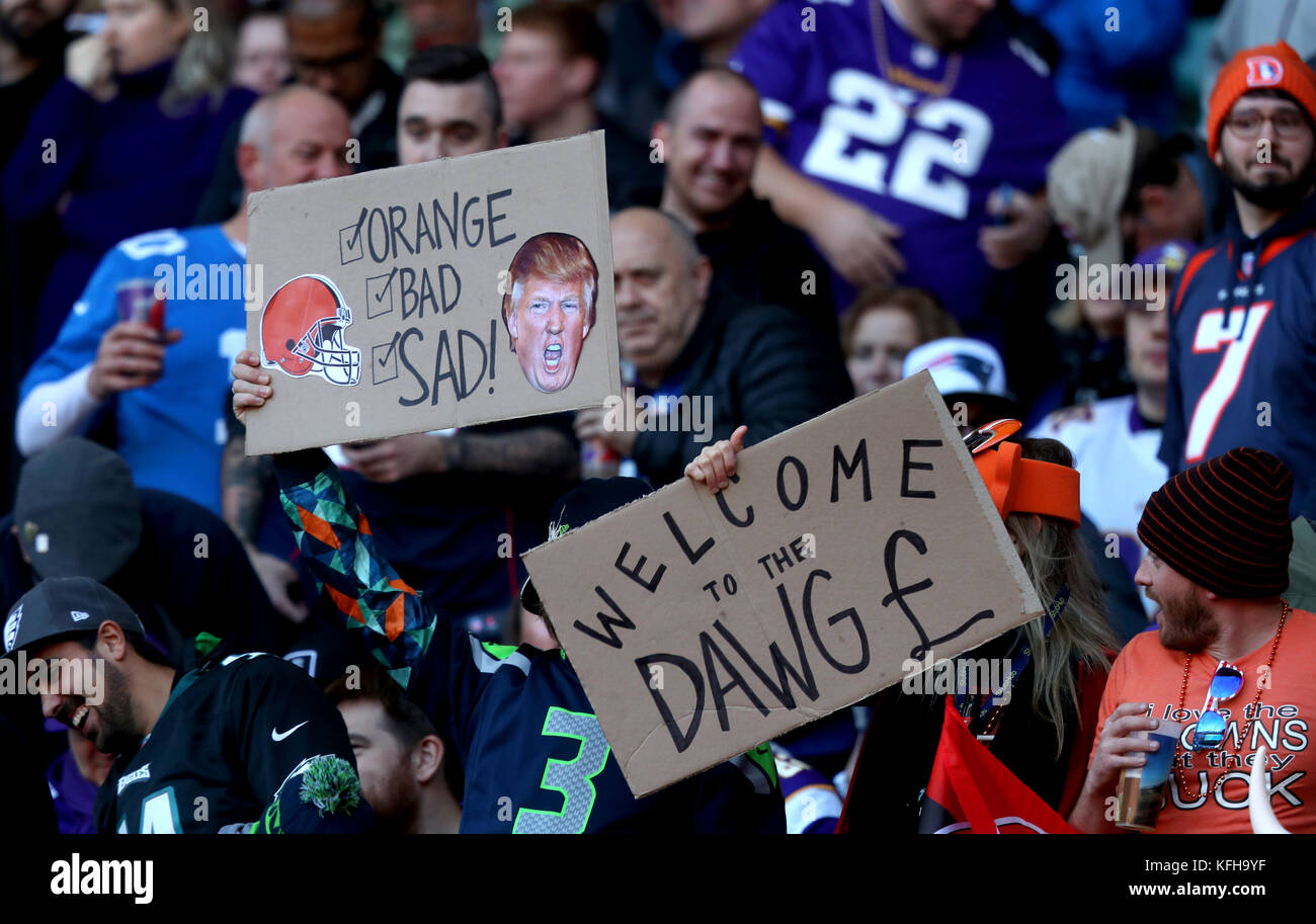 Fans in the stands hold up signs reading 'Orange, Bad, Sad!' and 'Welcome to the Dawg Pound' during the International Series NFL match at Twickenham, London. Stock Photo