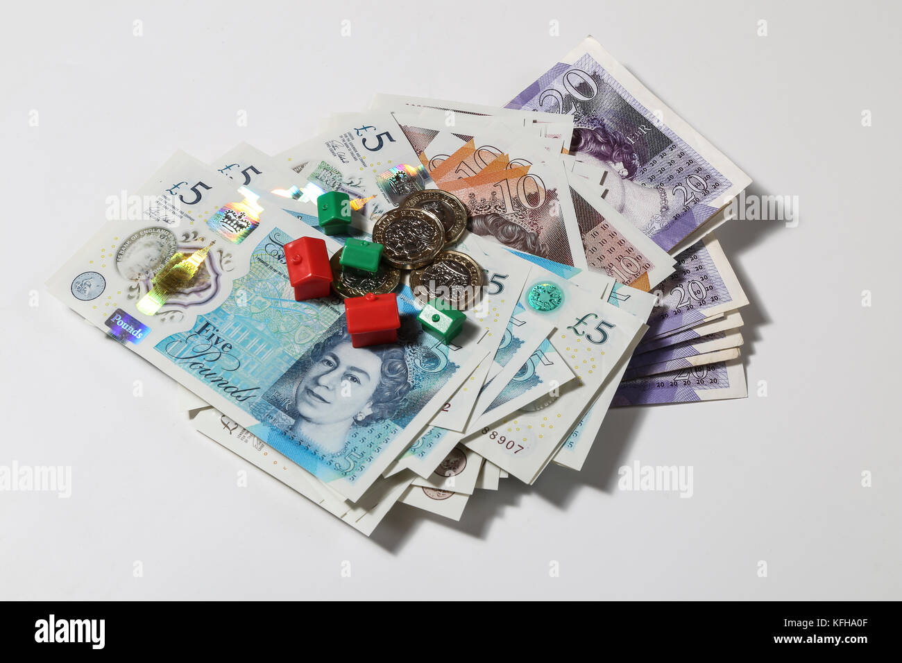 New British £5 and £10 notes with red and green monopoly houses and hotels Stock Photo