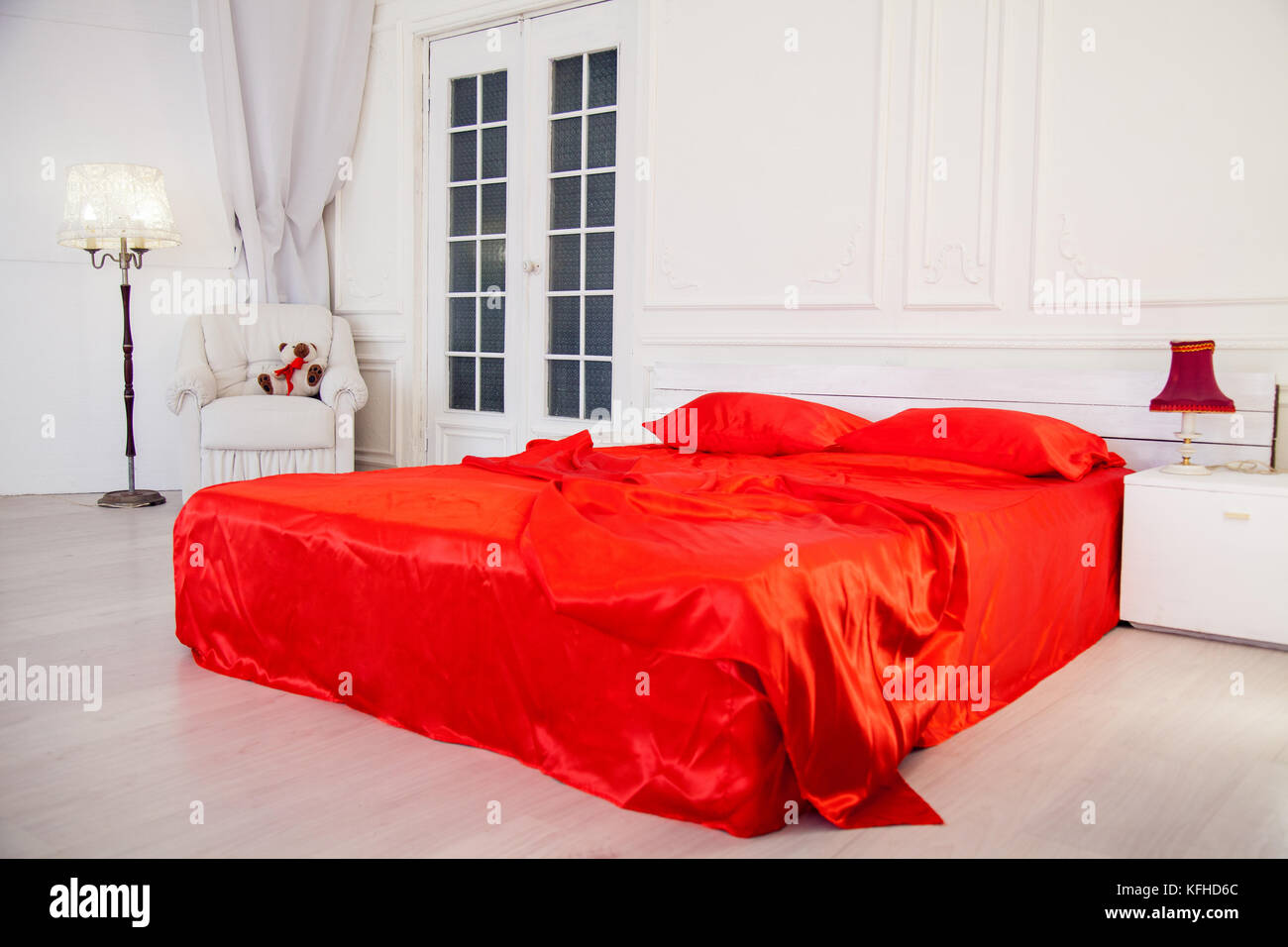 bed with red sheets in white bedroom Interior Stock Photo Alamy