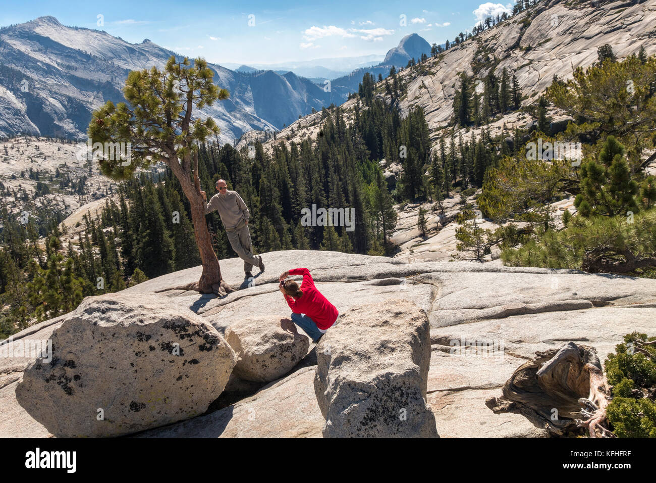 Olmsted Point Yosemite Couple taking photos with Half Dome in the distance in Yosemite National Park Stock Photo