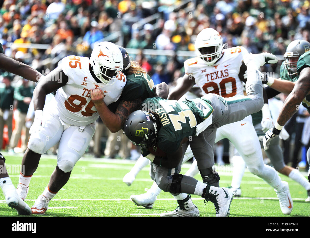 Waco, Texas, USA. 28th Oct, 2017. Baylor Bears running back JaMycal Hasty (33) tackled by Texas Longhorns defensive lineman Poona Ford (95) during the NCAA Football game between the Baylor Bears and the Texas Longhorns at McLane Stadium in Waco, Texas. Matthew Lynch/CSM/Alamy Live News Stock Photo