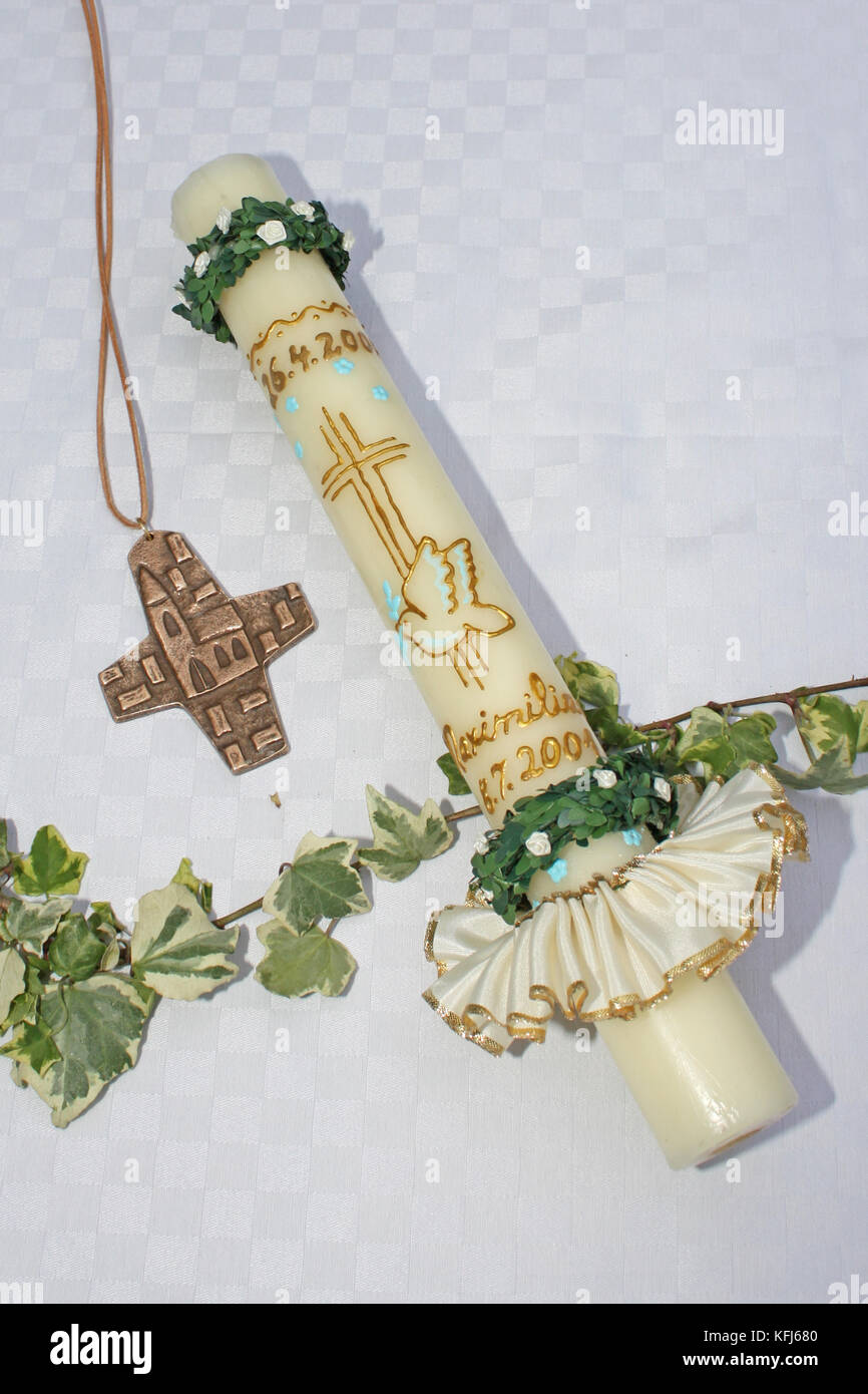 Erstkommunion, Kerze zur 1. hl. Kommunion mit Kreuz, Blumen und Efeu Stock Photo
