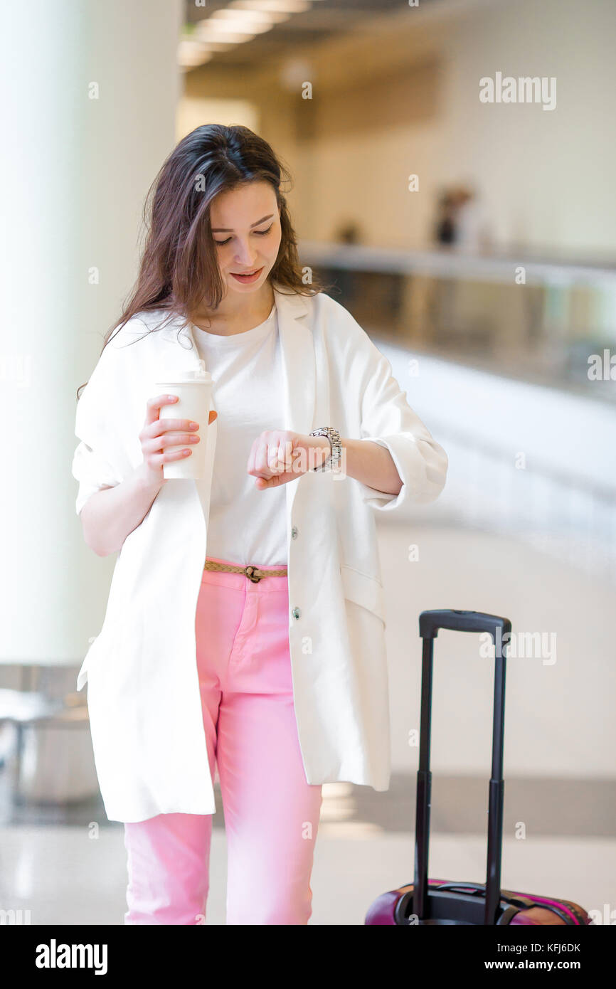 Young woman in international airport walking with her luggage Stock ...
