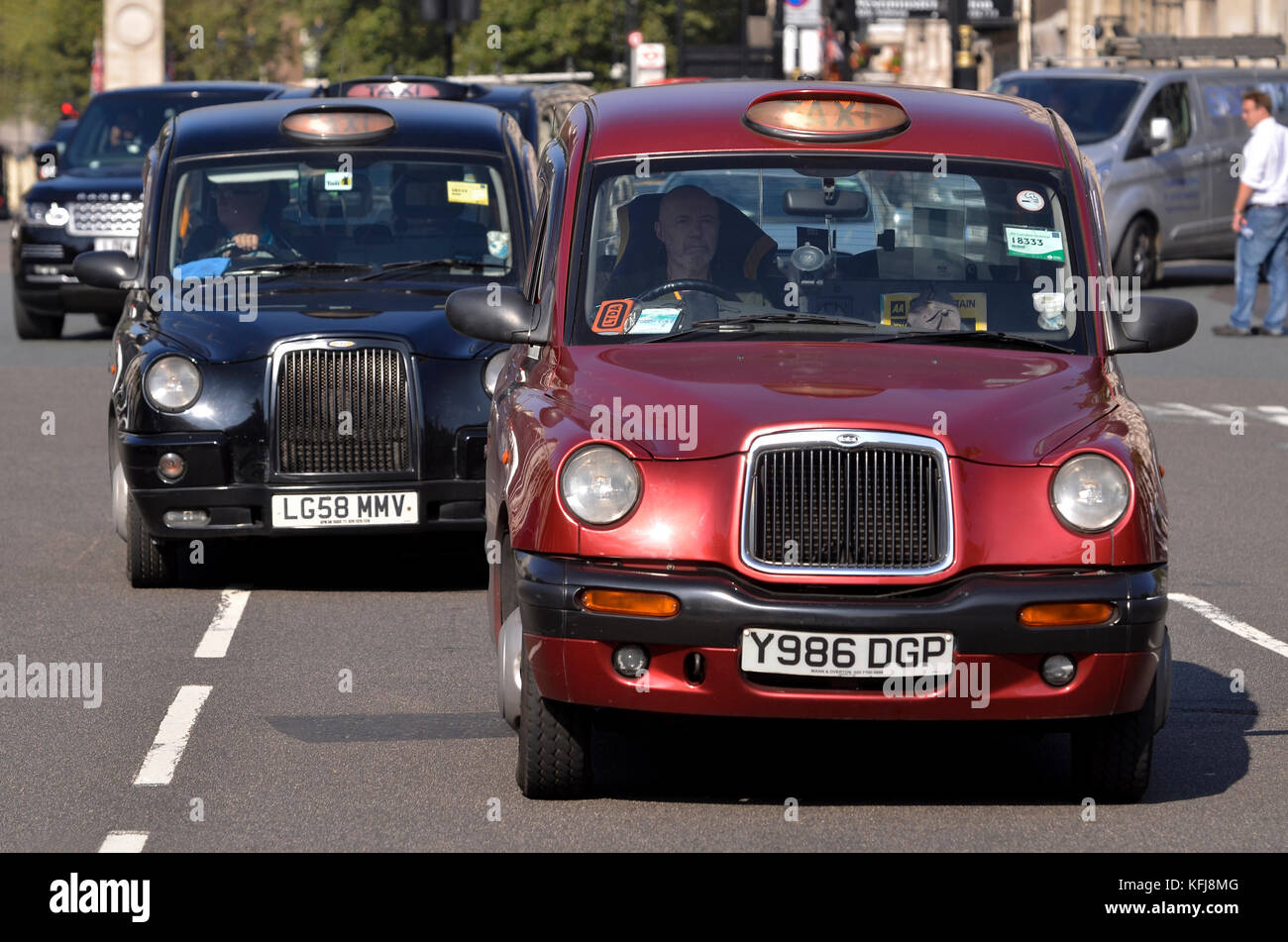 London taxi cabs in traffic, Westminster, London. Both are TX4 taxi cabs manufactured by The London Taxi Company, formerly LTI Vehicles. Stock Photo