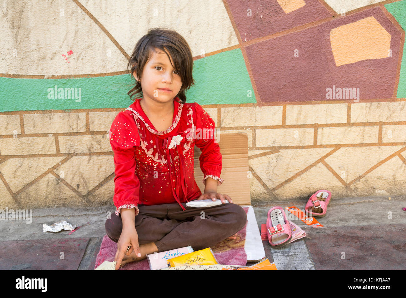 Tehran, IRAN - August 16, 2017 A little girl selling small tissue packages at street pavement Stock Photo
