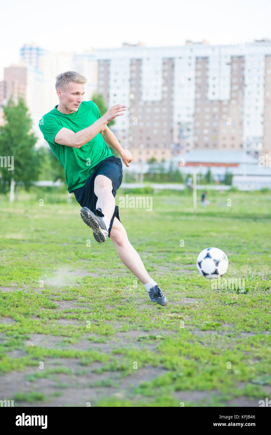 Soccer player strongly hits the ball Stock Photo Alamy