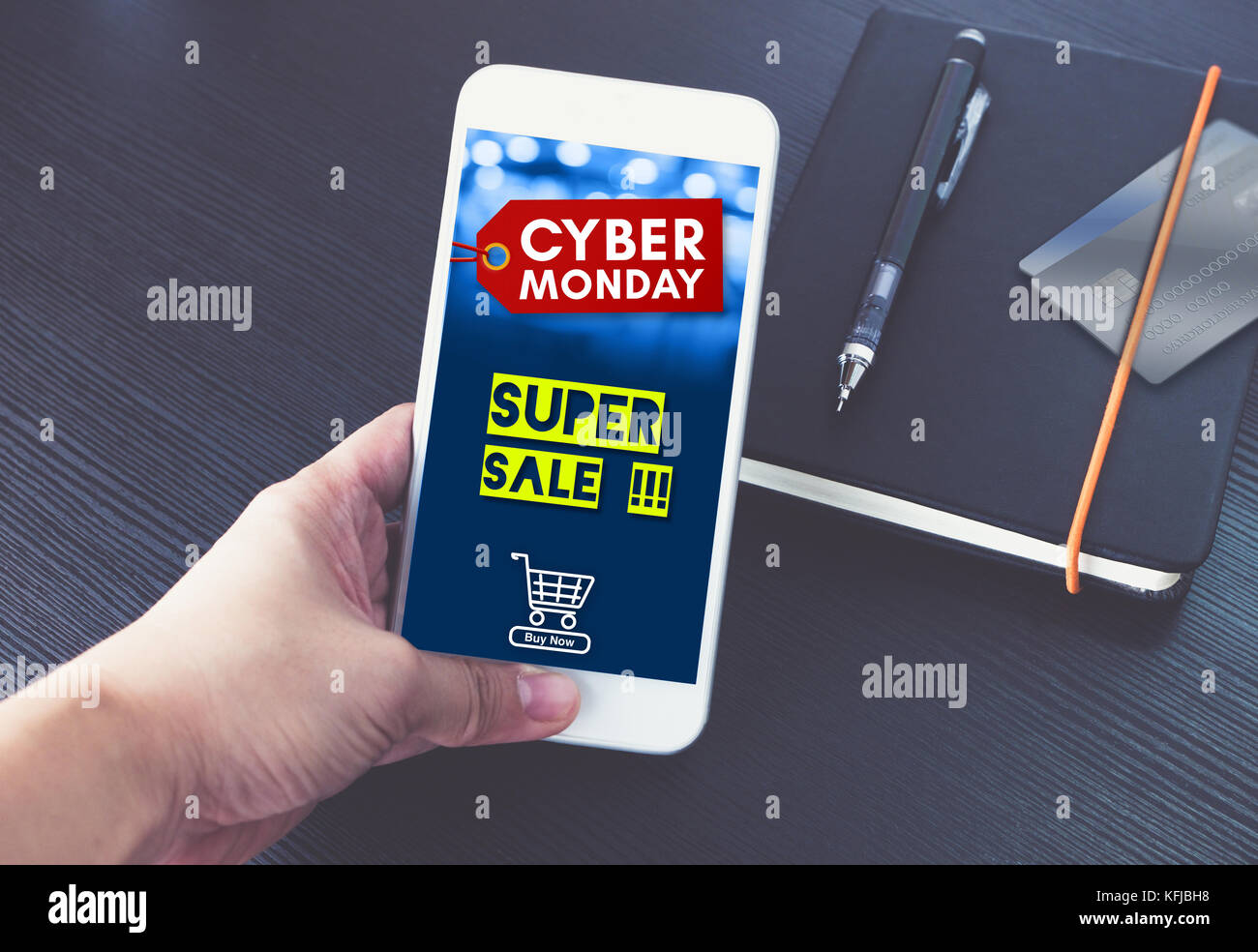 Cyber monday sale tag with shopping cart on mobile screen,Hand holding  smart phone over black book and credit card to shop online in  apps,E-commerce c Stock Photo - Alamy