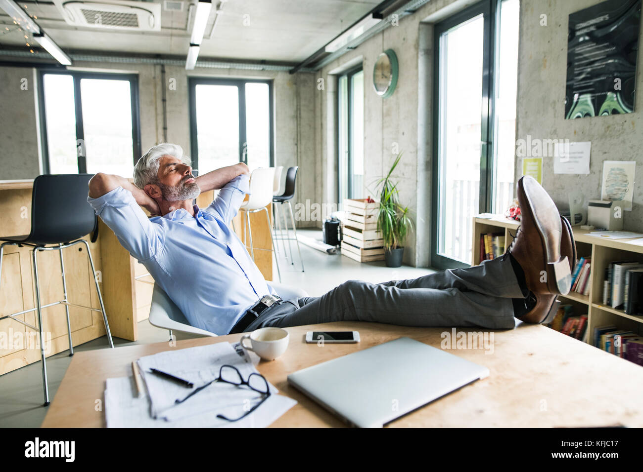 https://c8.alamy.com/comp/KFJC17/thoughtful-mature-businessman-with-smartphone-in-the-office-KFJC17.jpg