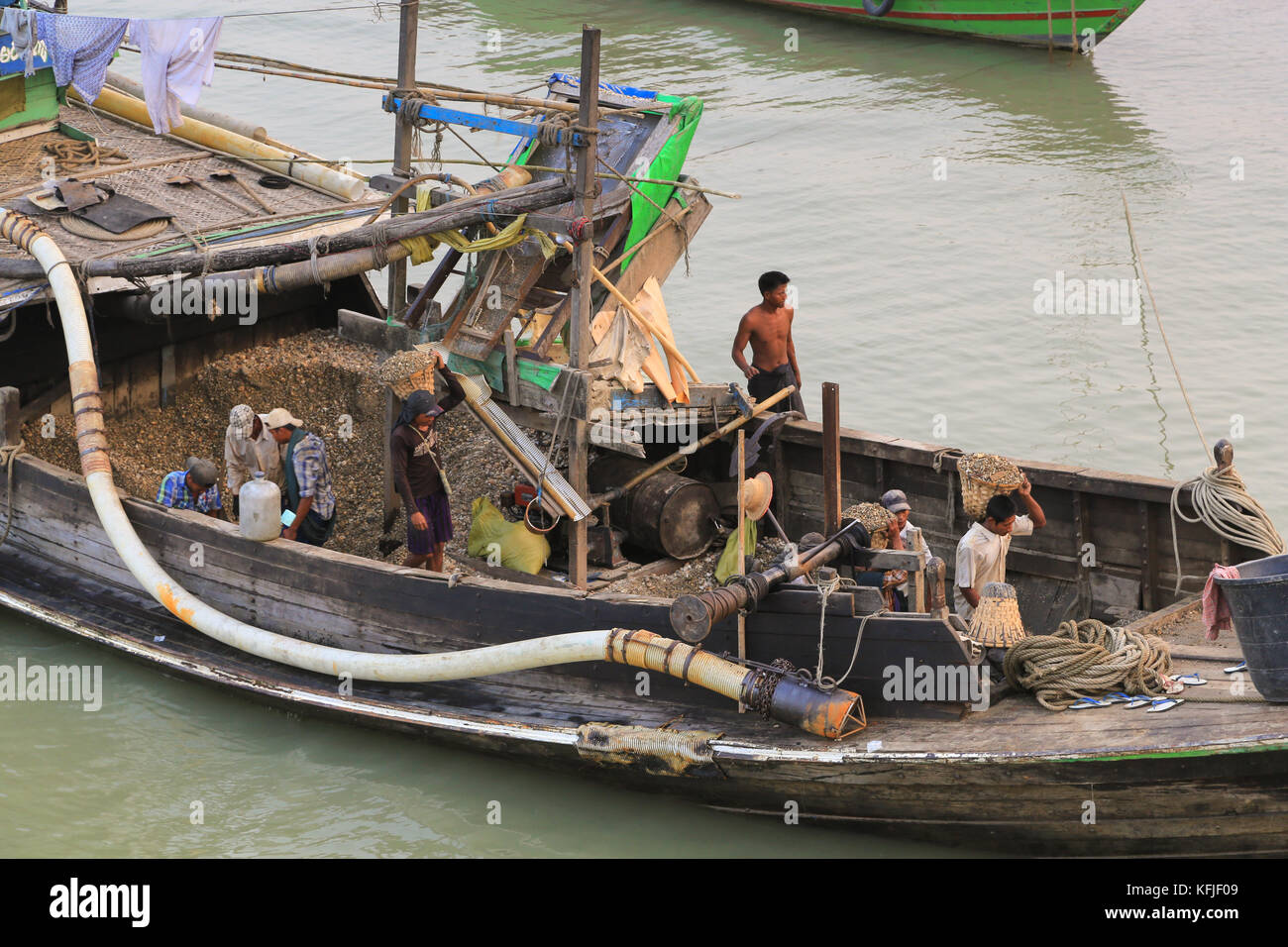 Workers unloading gravel from a boat at Danubyu, a town on the right (west) bank of the Irrawaddy River in Ayeyarwady Province of Myanmar (Burma). Stock Photo