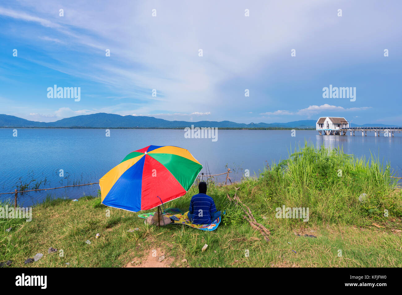 CHONBURI, THAILAND - AUGUST 10: This is Bang Phra reservoir with a fisherman sitting by the lake. Bang Phra is a popular fishing spot amongst locals o Stock Photo