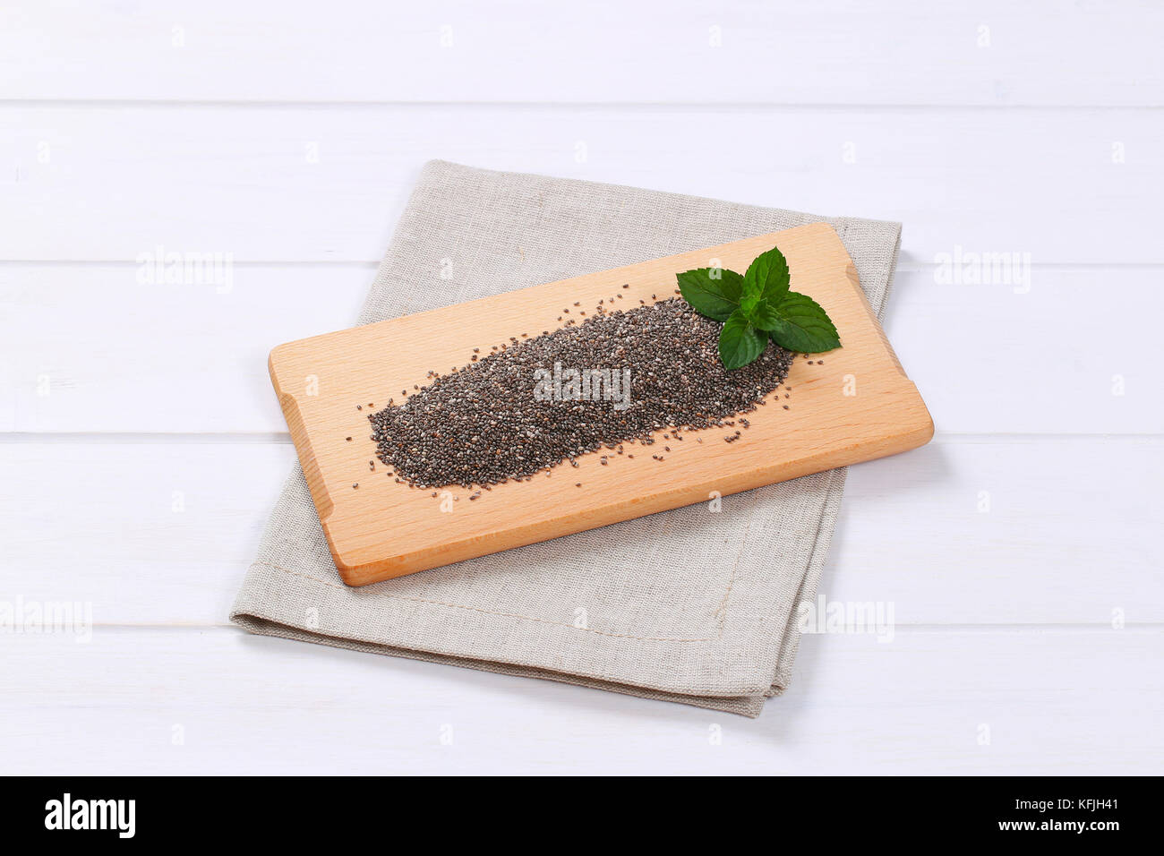 pile of chia seeds on wooden cutting board Stock Photo