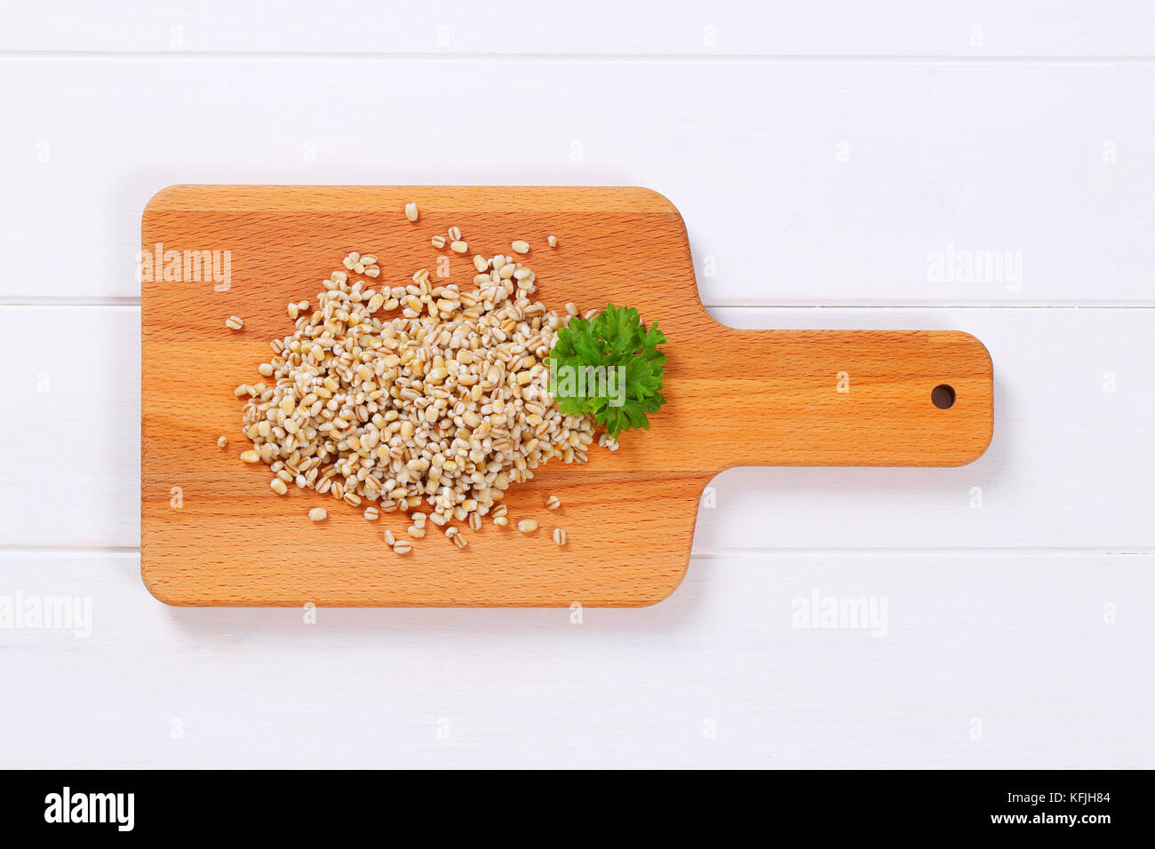 pile of cooked pearl barley on wooden cutting board Stock Photo