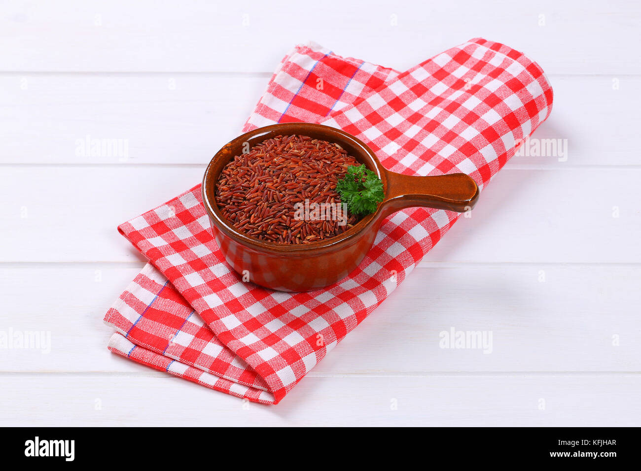 saucepan of red rice on checkered place mat Stock Photo