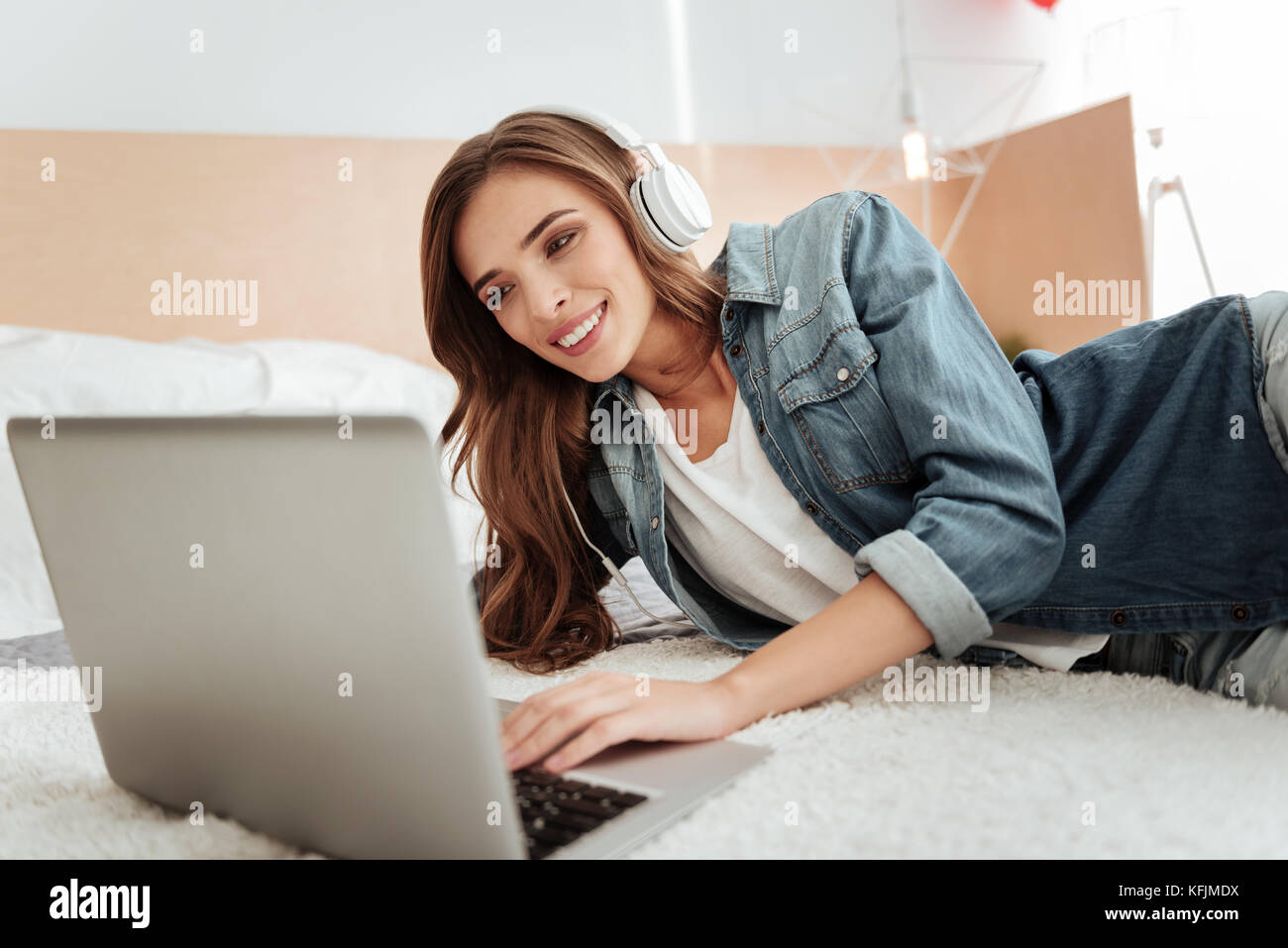 Cheerful girl smiling while working on laptop Stock Photo - Alamy