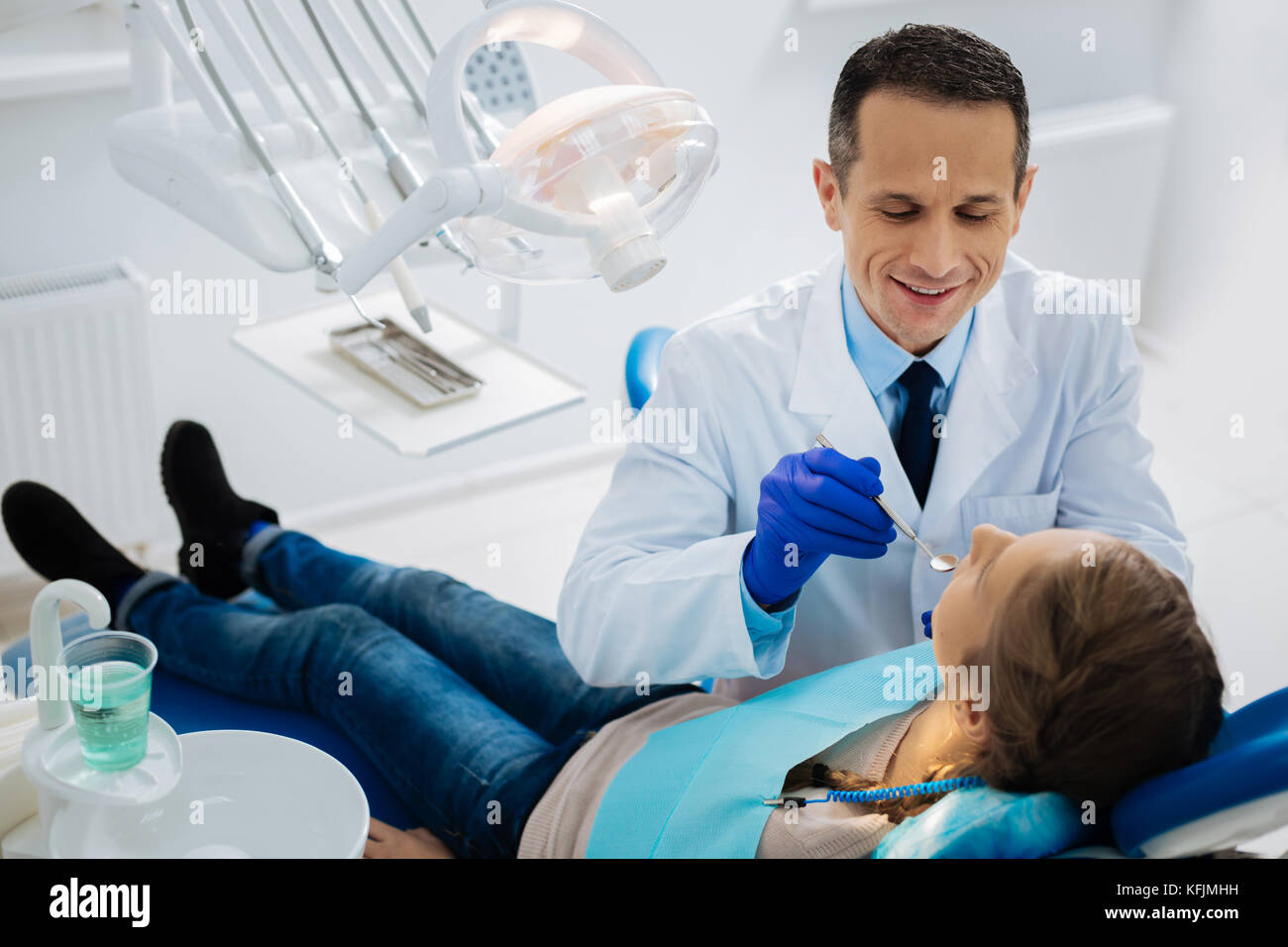 Delighted positive dentist doing his duties Stock Photo Alamy