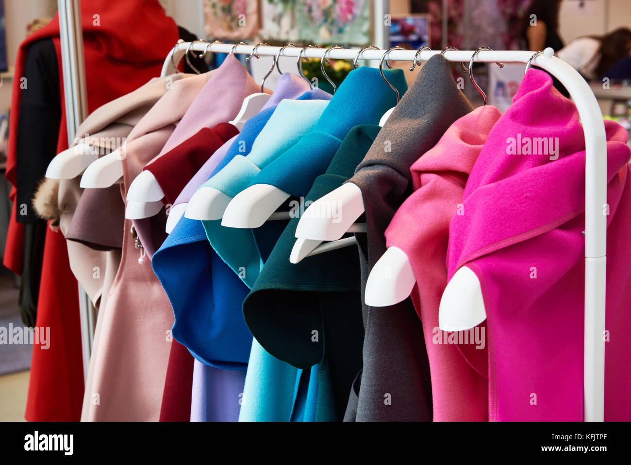 Cashmere colored fabrics like dresses on hangers in the store Stock Photo