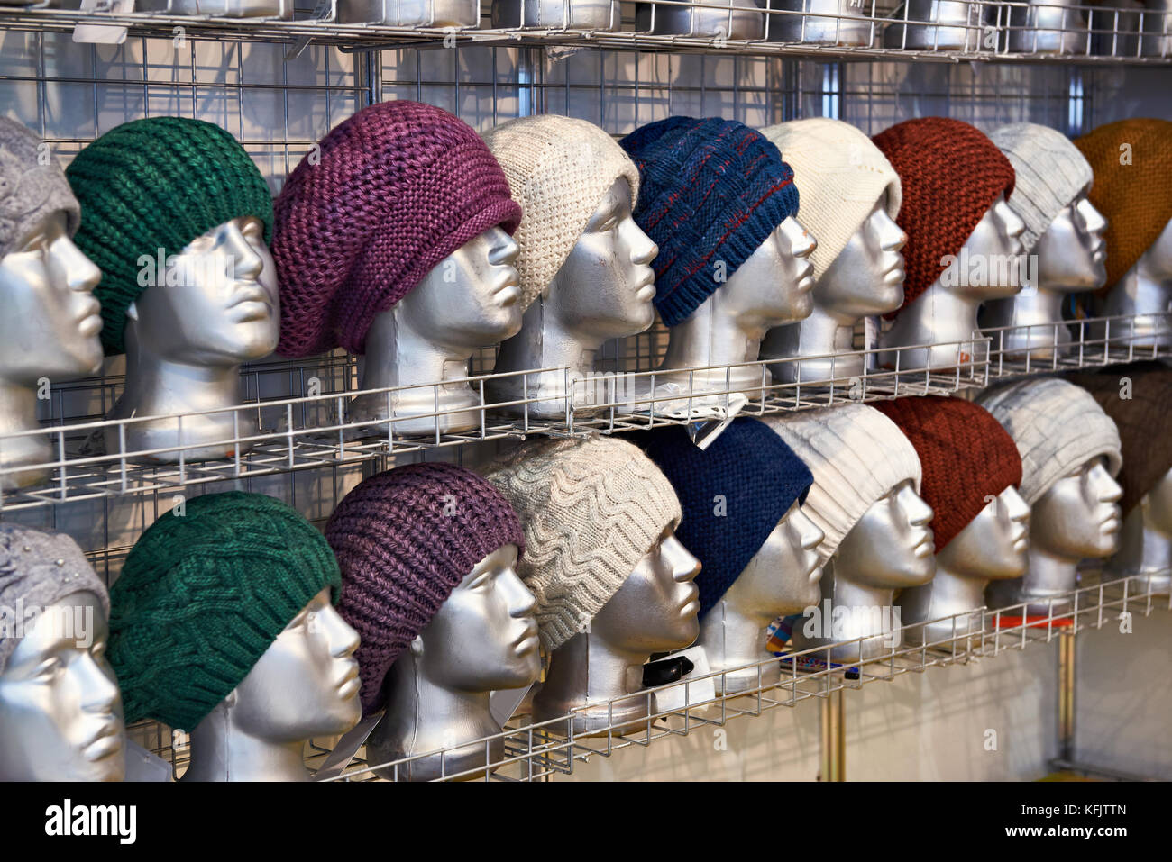 Woolen hats on the silvery heads of the mannequins in the store Stock Photo