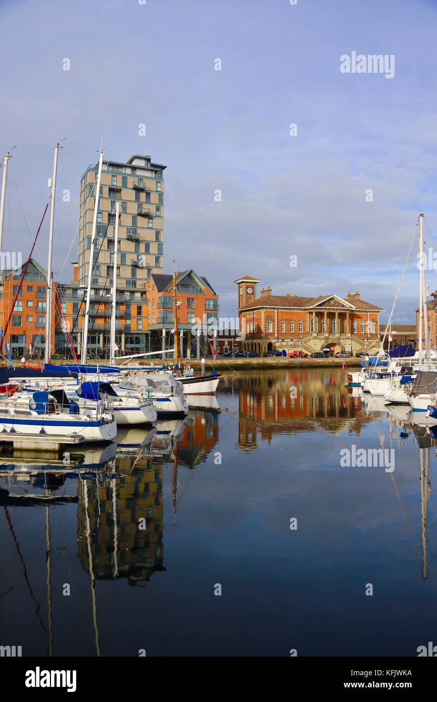 Boats, apartment buildings and reflections in Ipswich marina on a bright autumn afternoon. Stock Photo