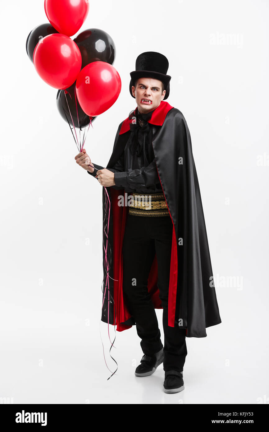 Fulllenght Portrait of handsome caucasian Vampire in black and red