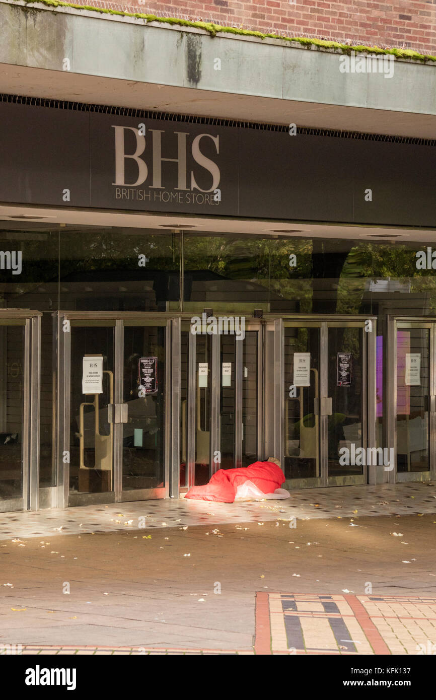Homeless person sleeping in the doorway of a closed BHS store, Coventry, England, UK Stock Photo