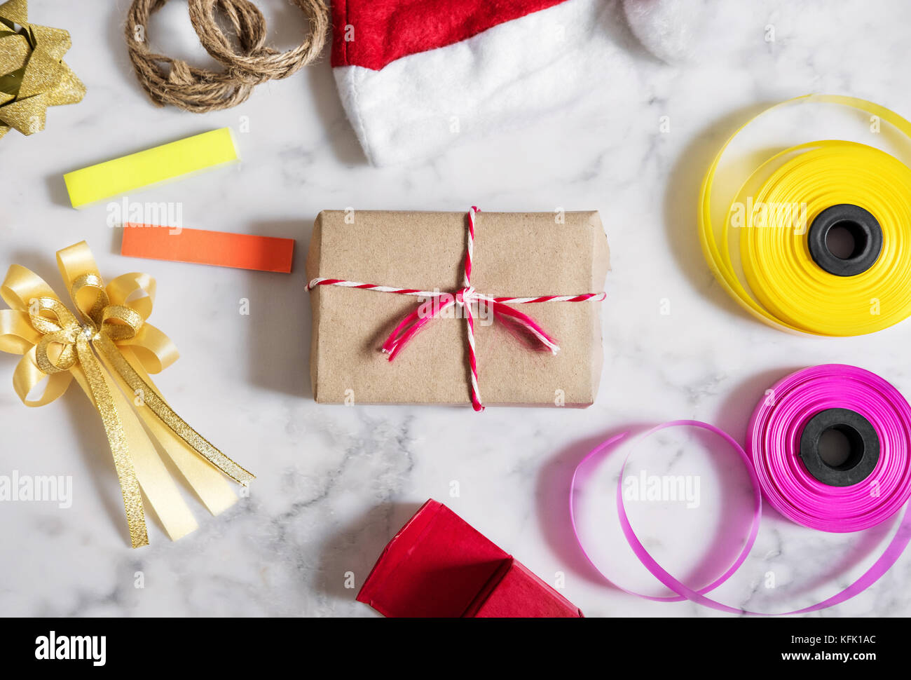 Christmas gifts preparation on white marble stone. Gift box with red