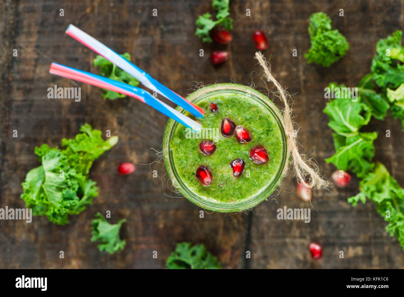 Healthy green kale and grapes smoothie garnished with pomegranate seeds