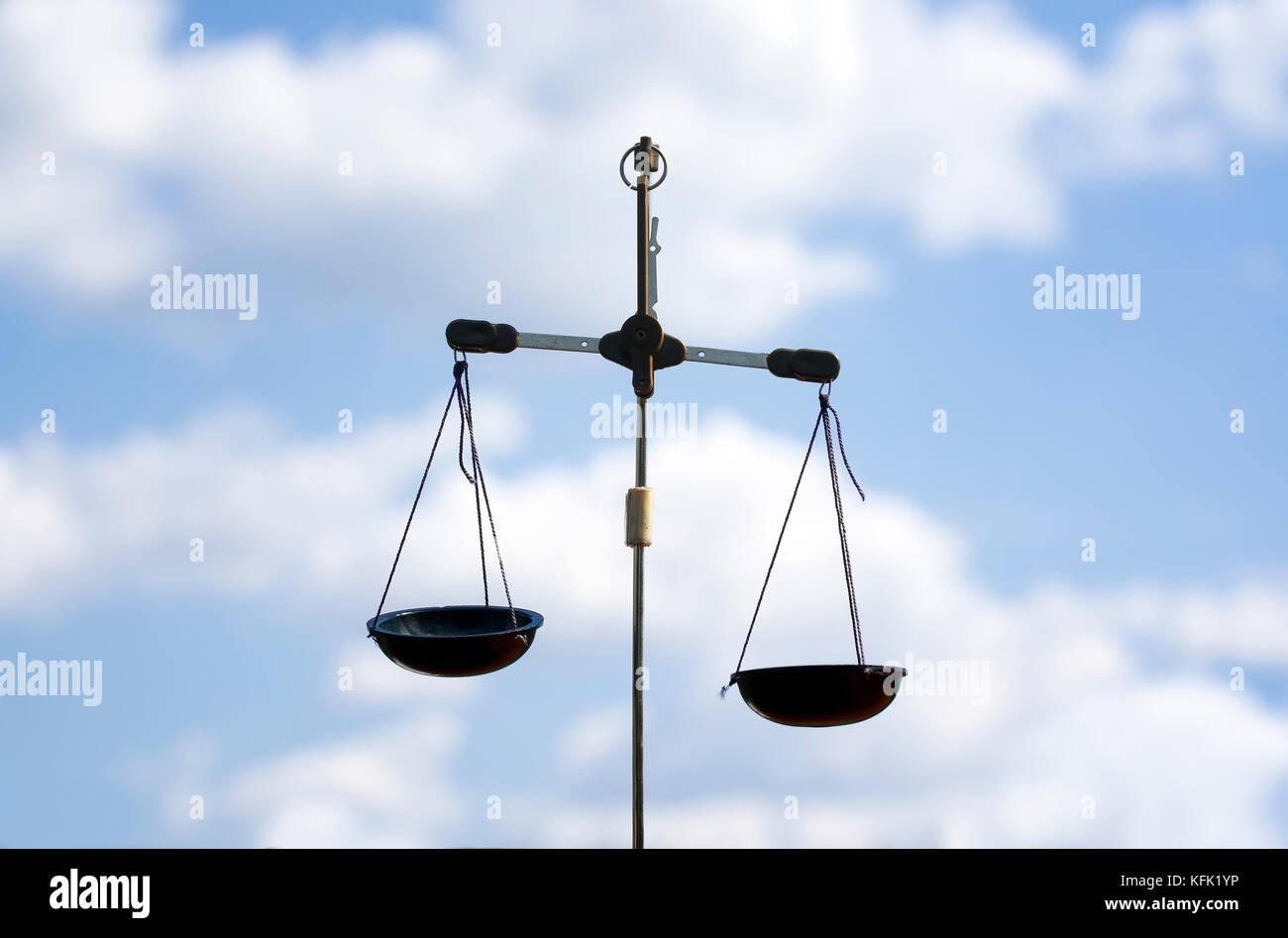 two scales hanging on blue sky background Stock Photo