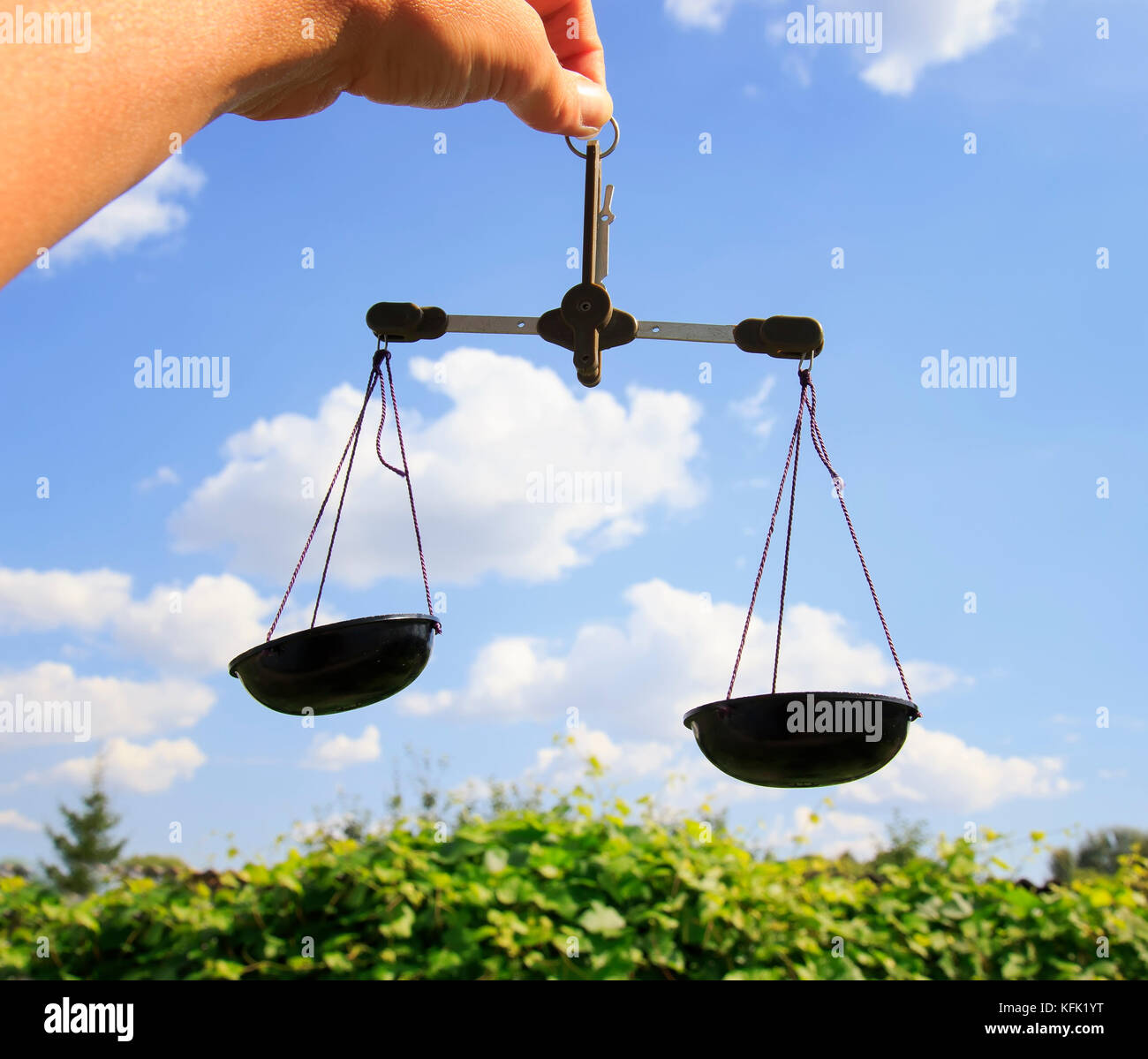 two scales on a background of blue sky in the hand Stock Photo