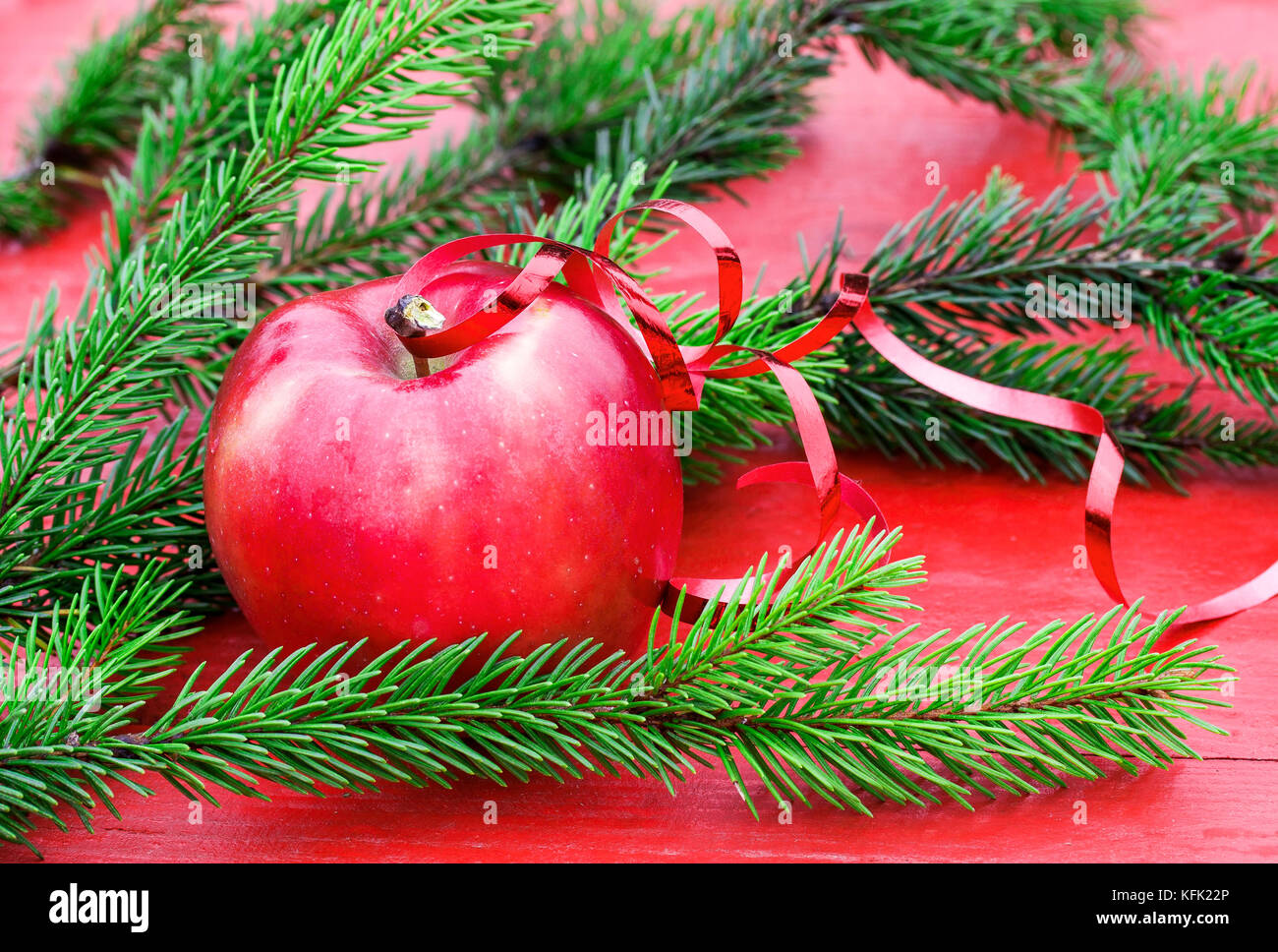 Christmas background of ripe red Apple on the table among the green fir branches Stock Photo