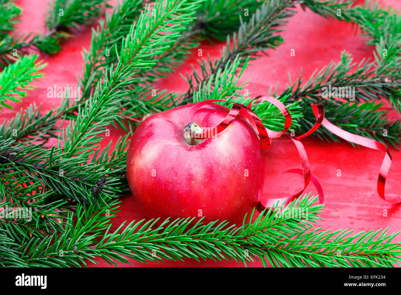 Christmas background of ripe red Apple on the table among the green fir branches Stock Photo