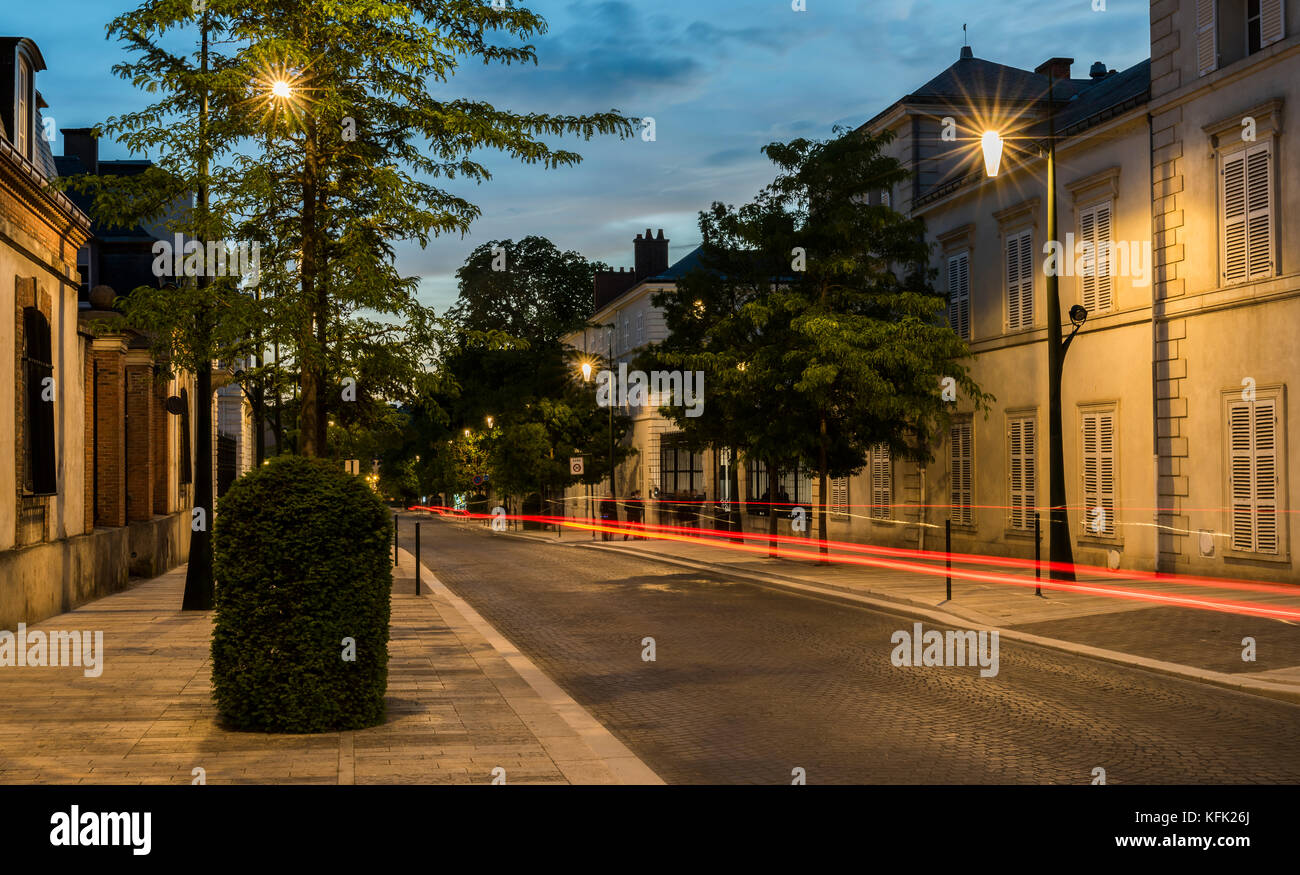 Epernay, France - June 13, 2017: Avenue de Champagne with several Champagne houses along the road during night and driving car with red lights in Eper Stock Photo