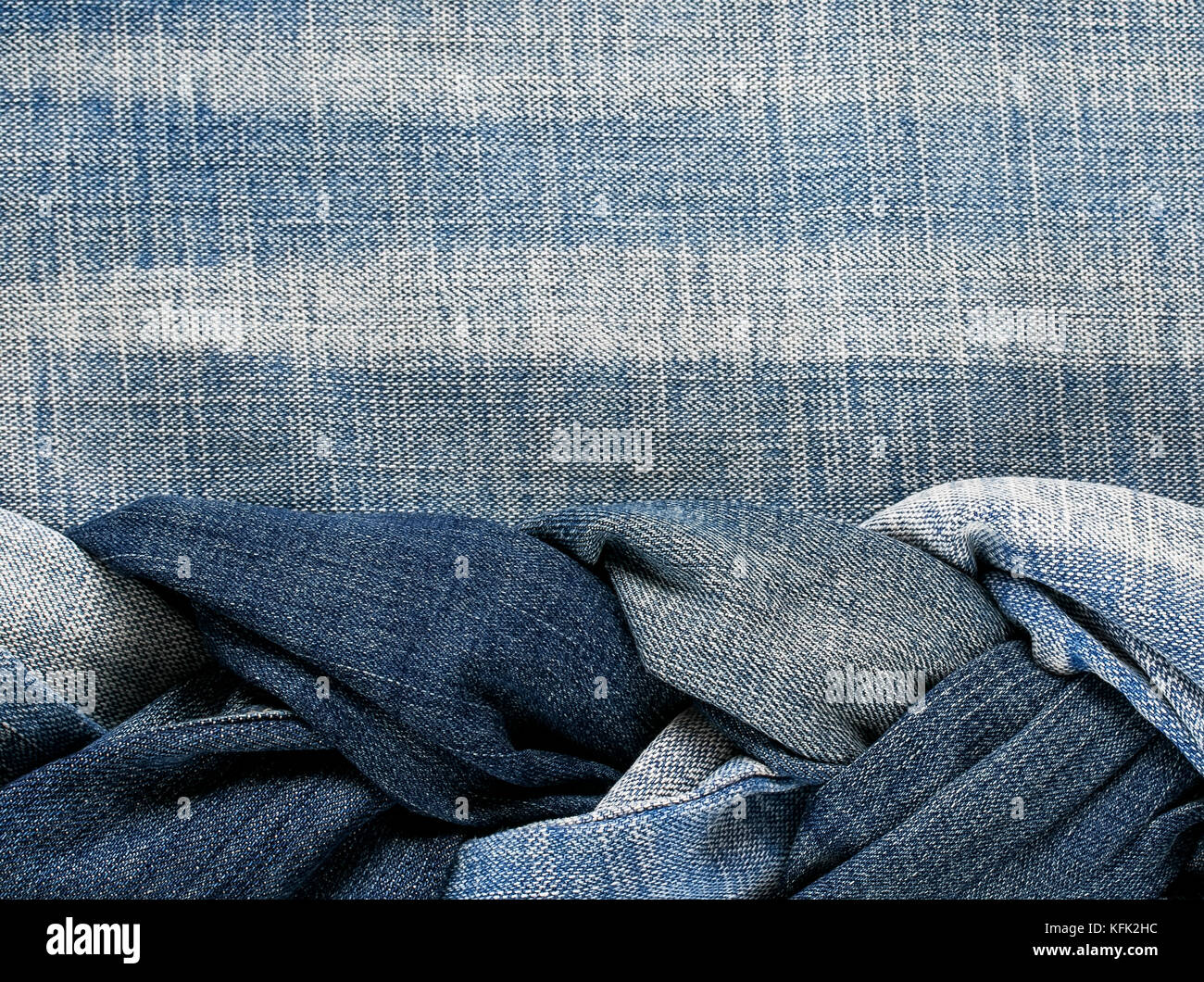 fashion stylish textured fabric background under the lettering's laced into a braid blue jeans of different colors Stock Photo