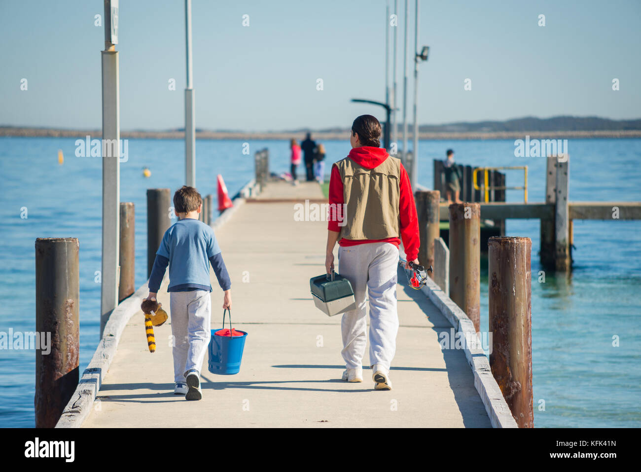 A father and his son walk along a jetty to go fishing in Cockburn Sound in the southern Perth
