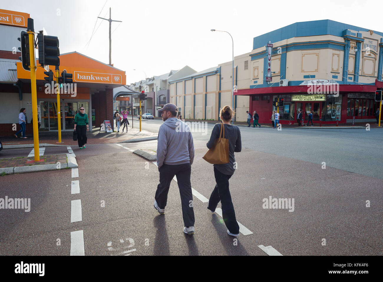 A man and a women use the pedestrian crossing on the corner of Vincent and Oxford Streets in Leederville, Perth, Western Australia. Stock Photo