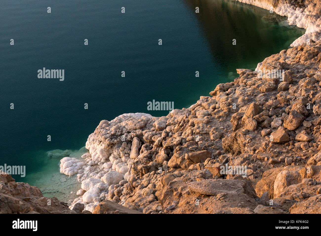 Dead Sea salt formations, called halite ooids, on shore edge, Jordan, Middle East, lit by low sun at dusk Stock Photo
