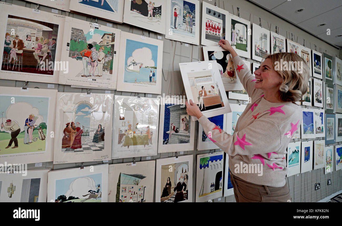 Auctioneer Catherine Southon holds examples from the Smilby cartoon collection, including works that appeared in Playboy, as she sets up her sale room in Farleigh, Surrey, ahead of their auction on the 1st of November. Stock Photo