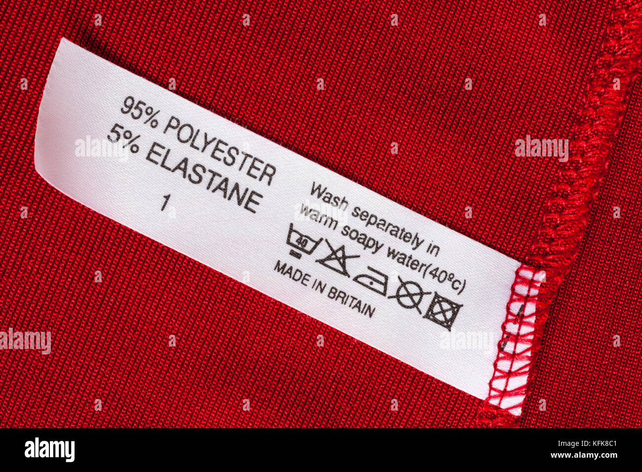 95% polyester 5% elastane label in woman's red top made in Britain with wash care instructions and symbols Stock Photo