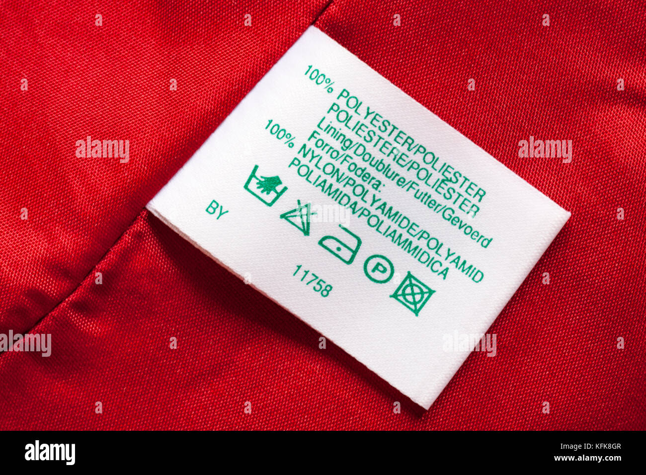 100% polyester lining 100% nylon label in woman's red clothing with wash care symbols instructions in different languages Stock Photo