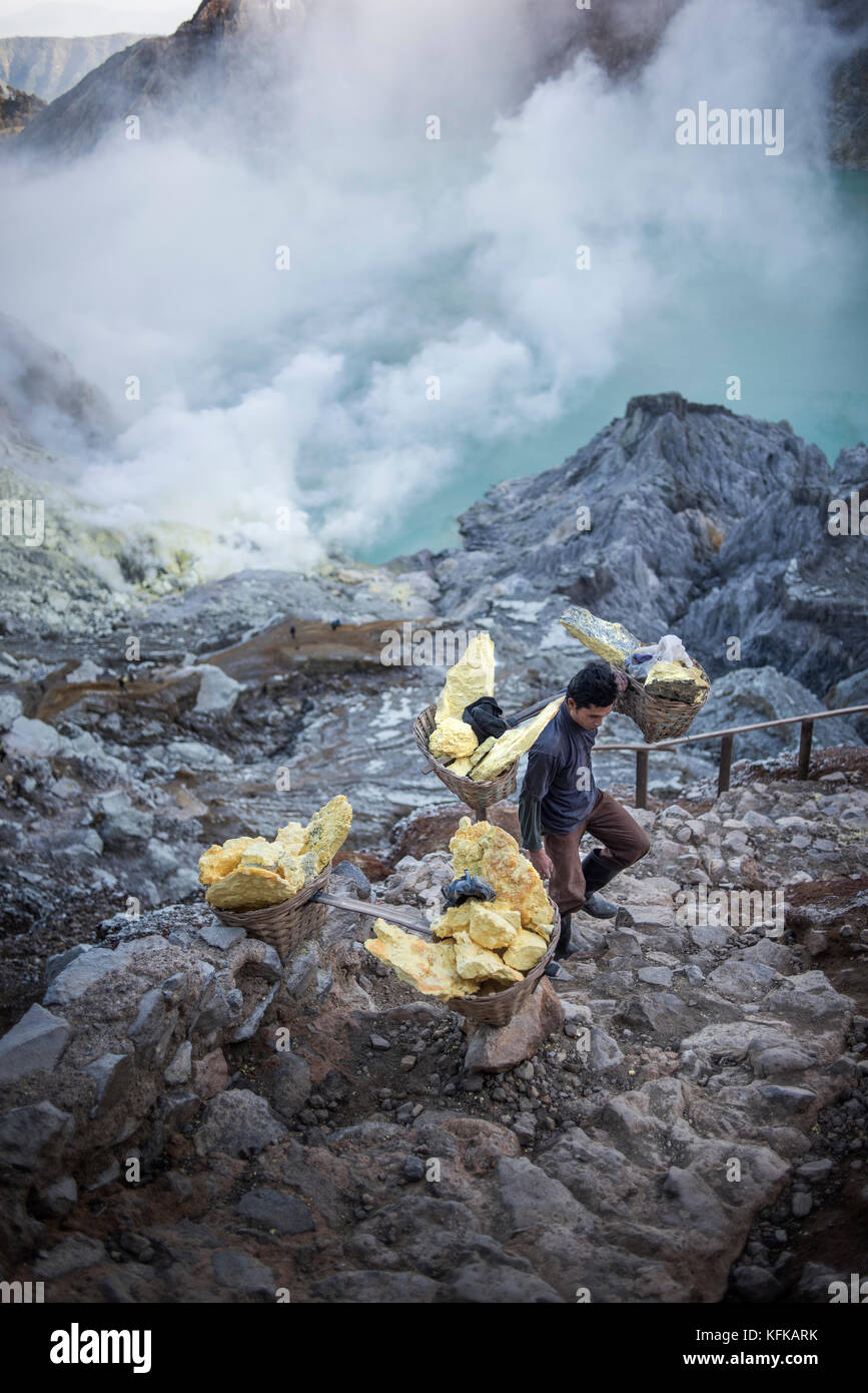 A Sulpur miner carrys a heavy load of raw sulfur up the Volcavo crater ...