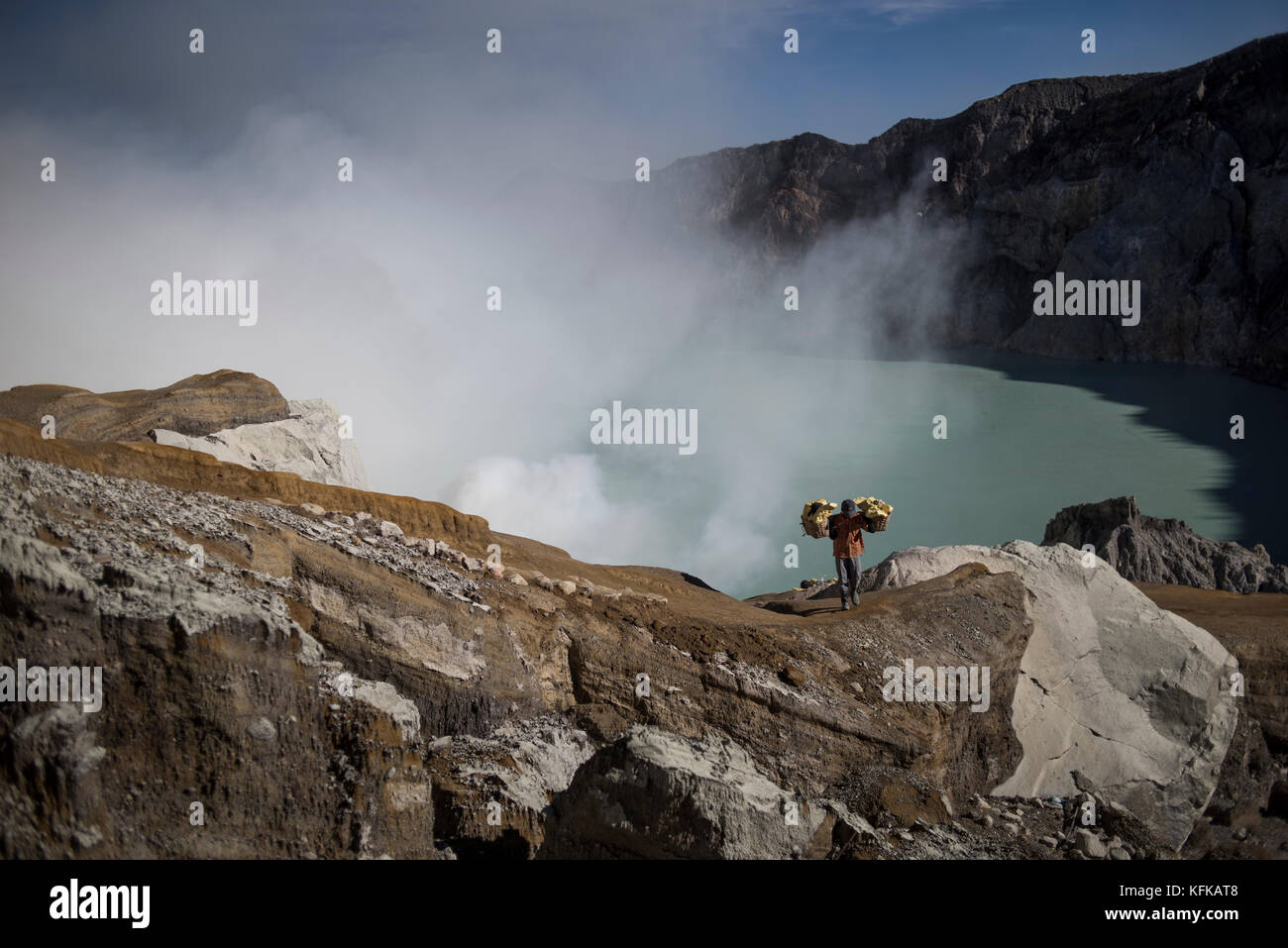 A sulfur miner going to the crater top carrying a basket full of sulfur ...