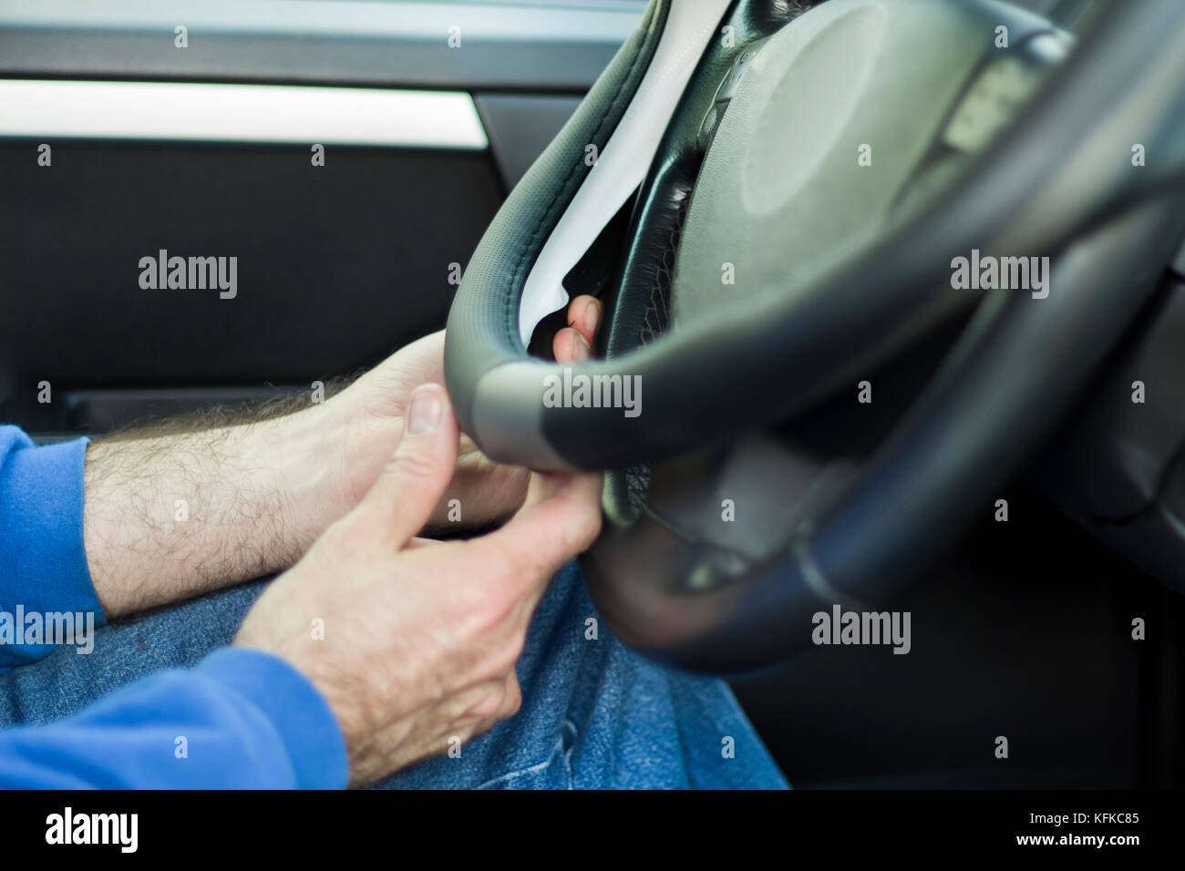 The mechanic puts weel cover on the steering wheel of the car. Auto