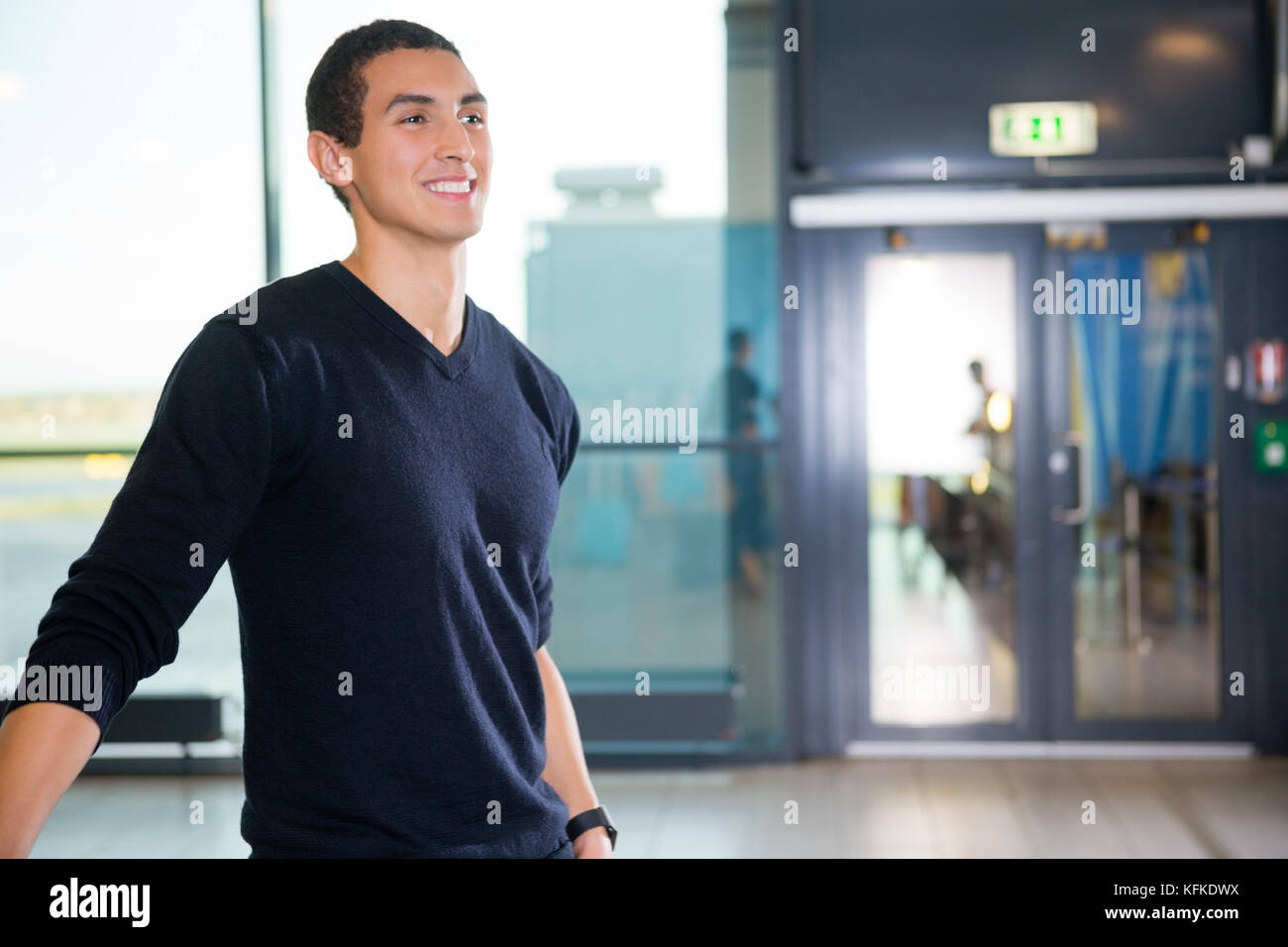 Smiling Male Passenger At Airport Terminal Stock Photo