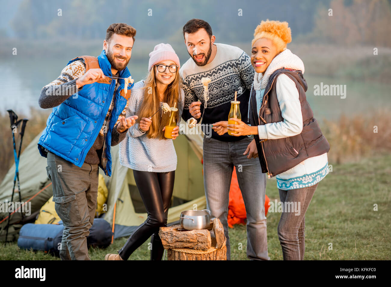 Friends in sweaters eating fondue outdoors Stock Photo Alamy