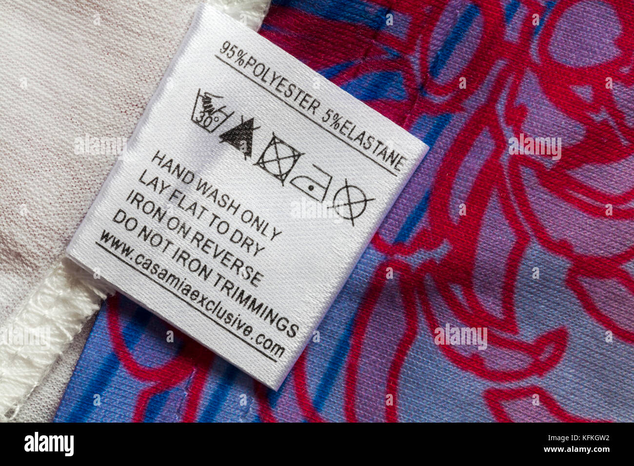 95% polyester 5% elastane label in woman's top with wash care instructions and symbols Stock Photo