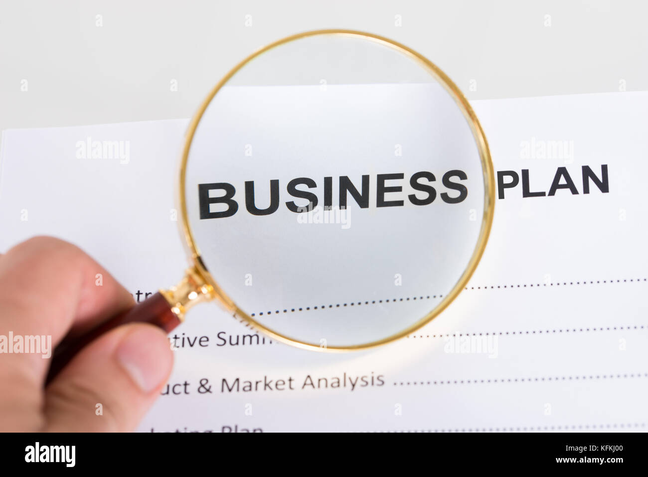 Magnifying glass and business plan. Closeup shot Stock Photo