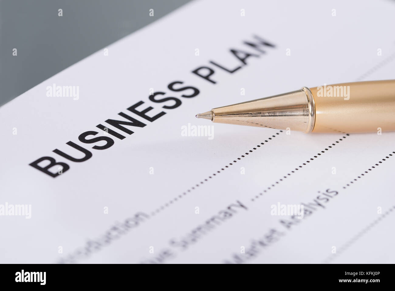 Business plan and golden pen. Closeup shot Stock Photo